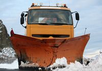 Orangener LKW mit Schneeschaufel